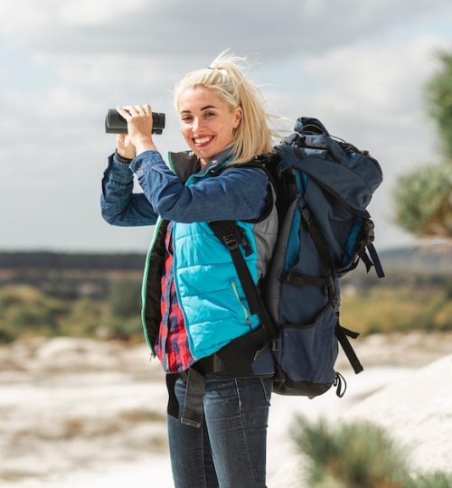 beautiful-woman-with-backpack-binoculars_23-2148315788