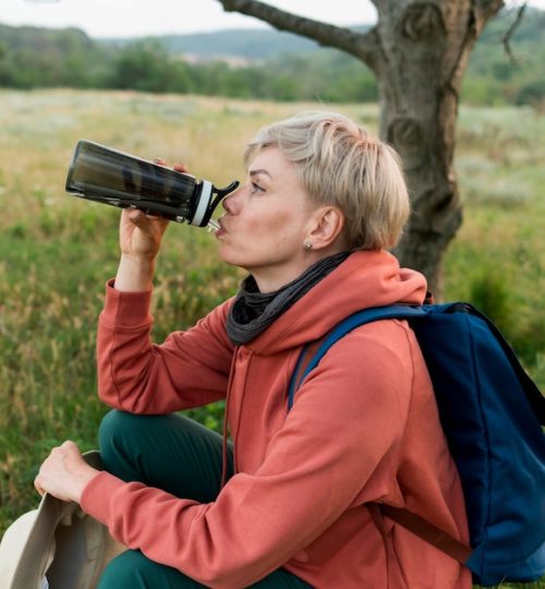 side-view-elder-tourist-woman-drinking-water_23-2148620172